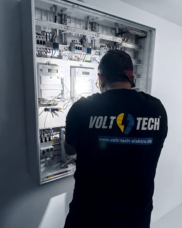 Zählerschrank im Wohnhaus, Volt Tech Monteur arbeitet an der Zählerplatte